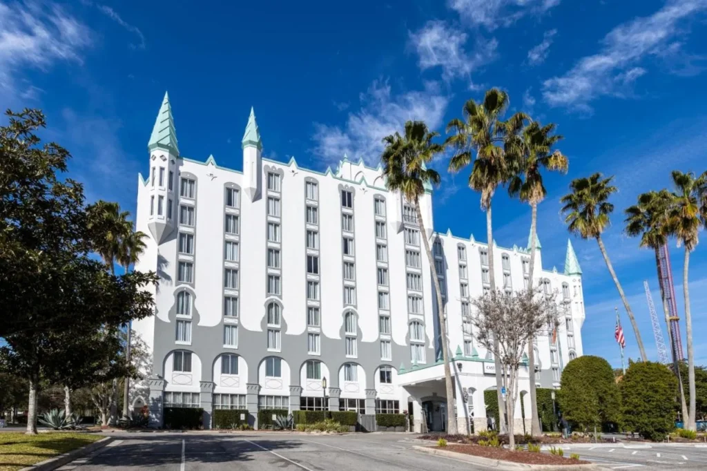 Fachada con torretas blancas y palmeras del Castle Hotel, colecci&oacute;n Autograph en Universal Boulevard