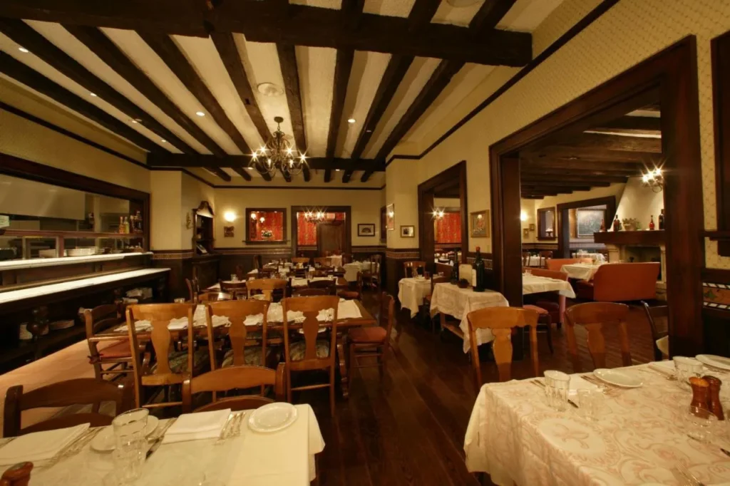 Comedor de restaurante italiano con vigas de madera con mesas en Loews Portofino Bay Hotel