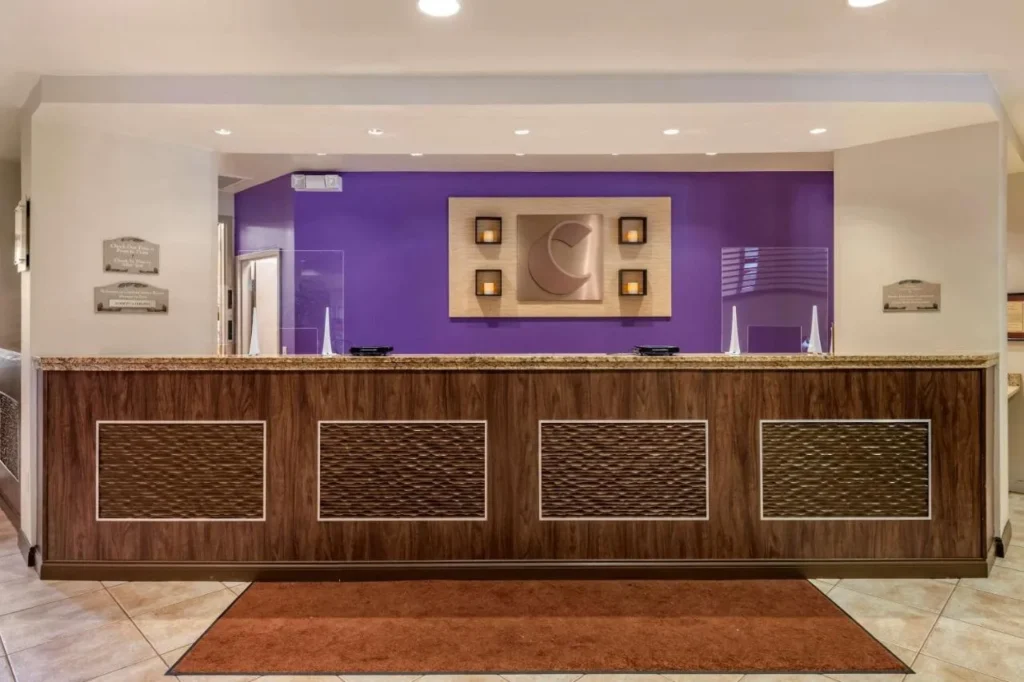 Recepci&oacute;n con paneles de madera con pared p&uacute;rpura en el vest&iacute;bulo del Comfort Suites Maingate East