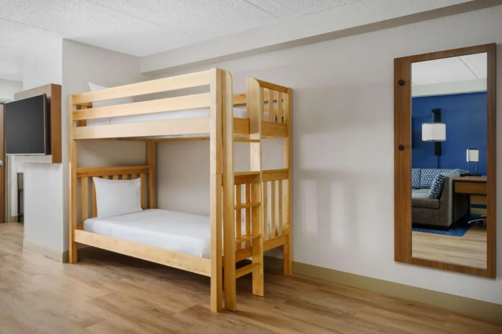 Camas de madera junto a un espejo alto en Hyatt Place across from Universal Orlando