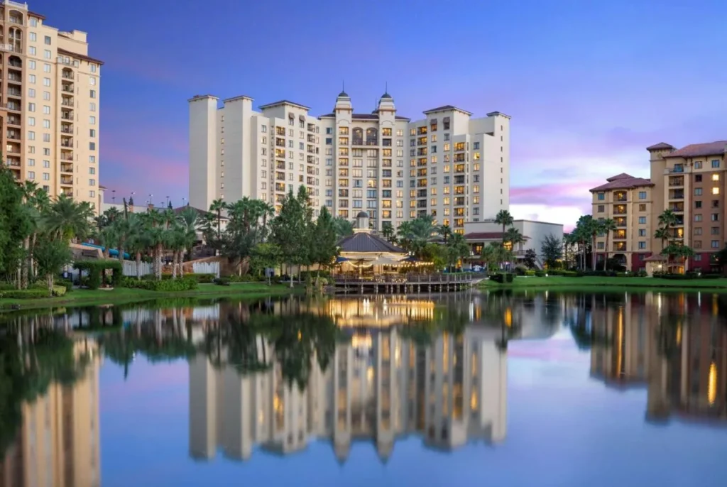 Wyndham Grand Orlando Bonnet Creek torre y pabellón junto al lago se refleja en el lago al atardecer