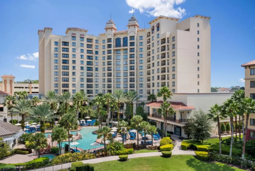 Wyndham Grand Orlando Resort Torre Bonnet Creek elevándose sobre las palmeras y la piscina