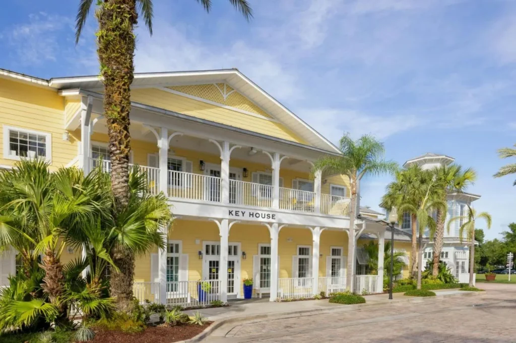 Edificio de Yellow Key House con porches blancos y palmeras en Marriott's Harbour Lake