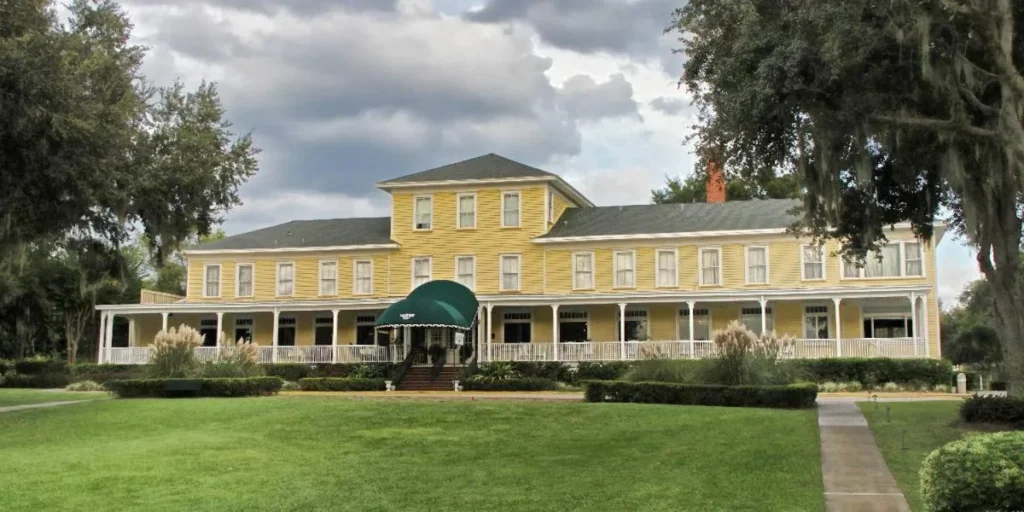 Yellow main building and long white verandah of the historic Lakeside Inn in Mount Dora