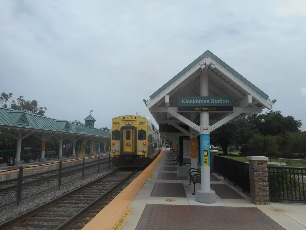 Yellow SunRail train at the covered northbound platform of the Kissimmee station in downtown Kissimmee