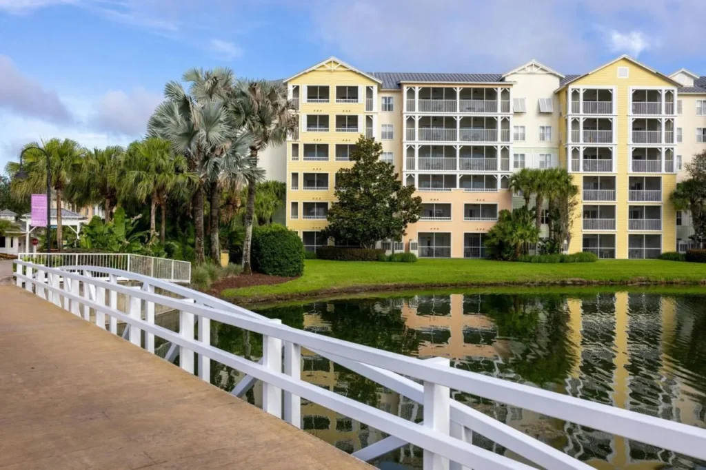 Yellow villa building and white bridge railing beside a pond at Marriott's Harbour Lake