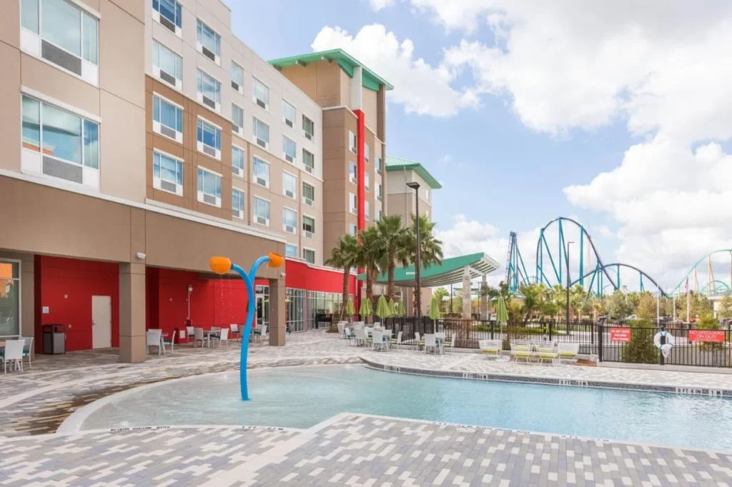 Piscina de entrada cero con función de salpicadura y posavasos SeaWorld detrás, Holiday Inn Express Orlando en SeaWorld