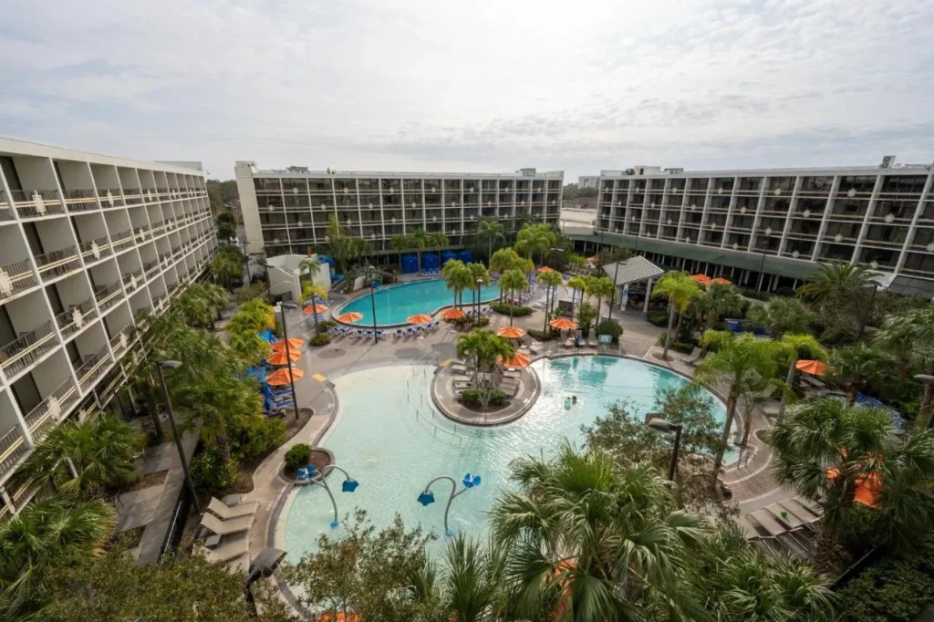 Piscina de entrada cero con rociadores y sombrillas naranjas en Sheraton Lake Buena Vista Resort
